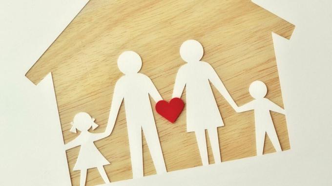 En papirfamilie på et trehus, som holder et hjerte for å representere kjærlighet, støtte og ADHD-hjelp