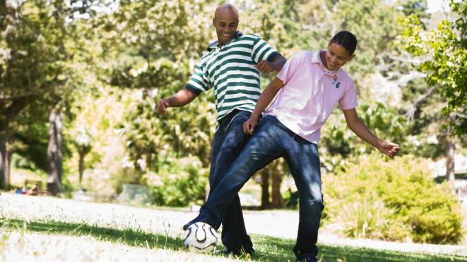En far som foreldrer tenåringen sin ved å spille et morsomt spill med fotball